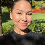 A photo of a filipino woman with her hair tied back and sunglasses on her head. She is wearing a black t-shirt with a logo on the upper right corner.